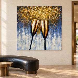 Two golden champagne flutes leaning together beneath gold-colored speckles on blue gray in an artwork with no outer frame, displayed above curved seating in a reception area.