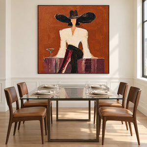 Black-framed seated-figure artwork behind a glass dining table.