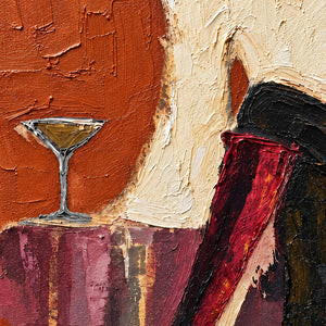 Close-up of the glass, cream sleeve, red boot, and raised orange texture.
