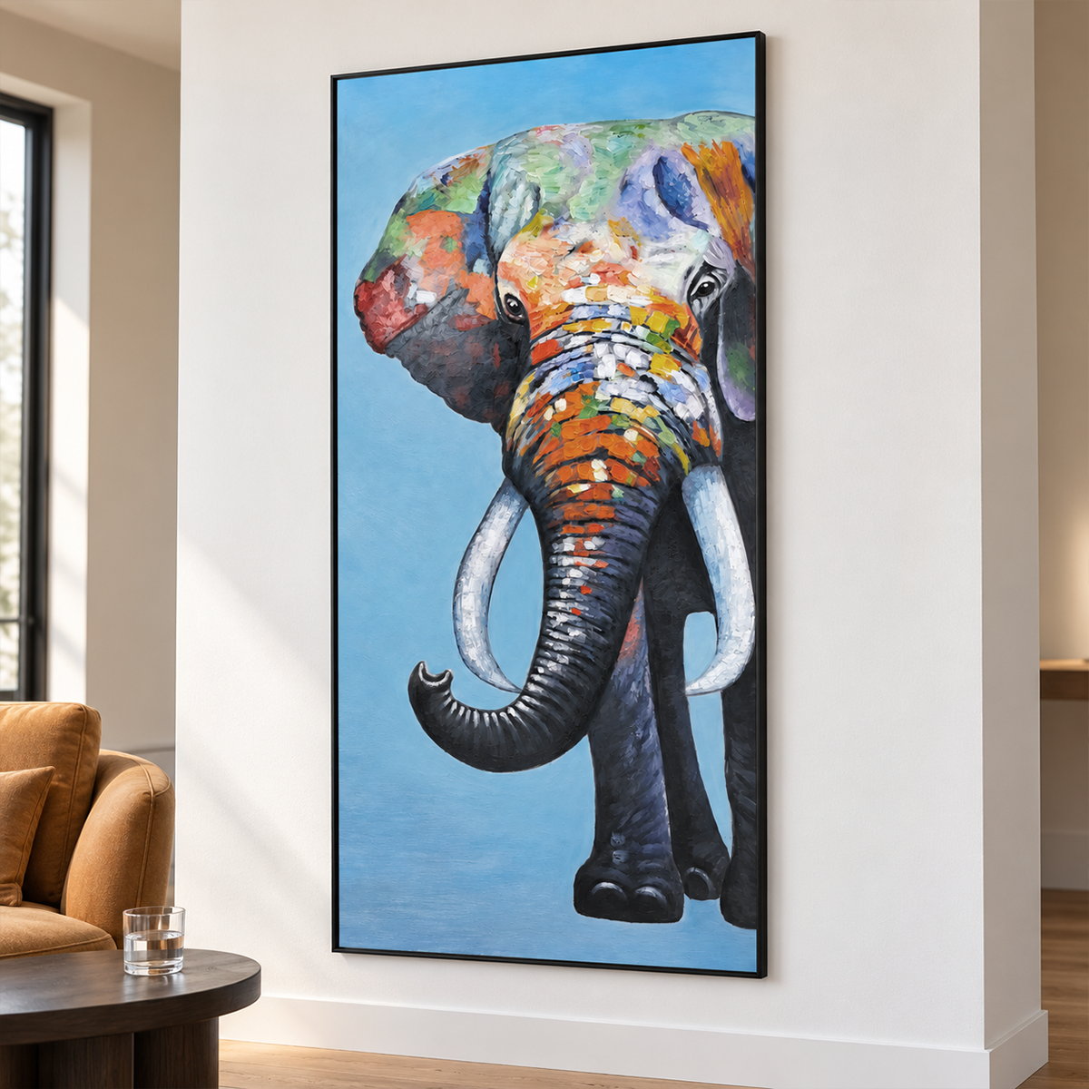 Artwork showing a front-facing elephant with an upcurled trunk, pale tusks and colored blocks on blue in a seating area, with a black frame.