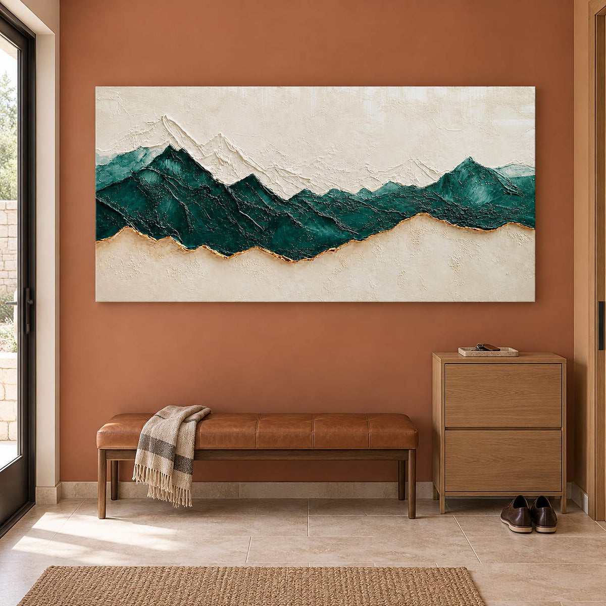 Hand-painted panoramic mountain wall art in emerald green, ivory, and gold, displayed in an entrance hall without an outer frame.