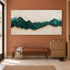 Hand-painted panoramic mountain wall art in emerald green, ivory, and gold, displayed in an entrance hall without an outer frame.