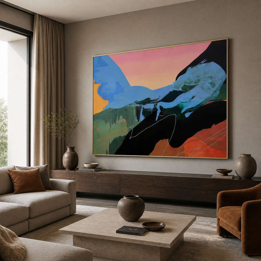 Blue and peach abstract painting in a gold frame above a neutral sofa.