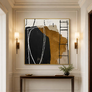 Gold framed black and ochre artwork above a narrow hallway console between warm sconces.