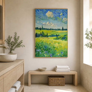 Gold-framed meadow landscape beside a stone basin and wooden bathroom bench.
