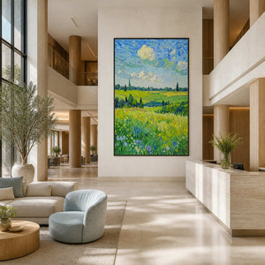 Black-framed field landscape above reception in a spacious hotel lobby with pale seating.