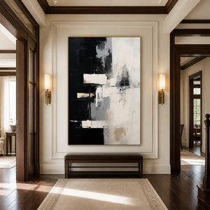 Gold framed black and white artwork above a leather bench in a traditional hallway.