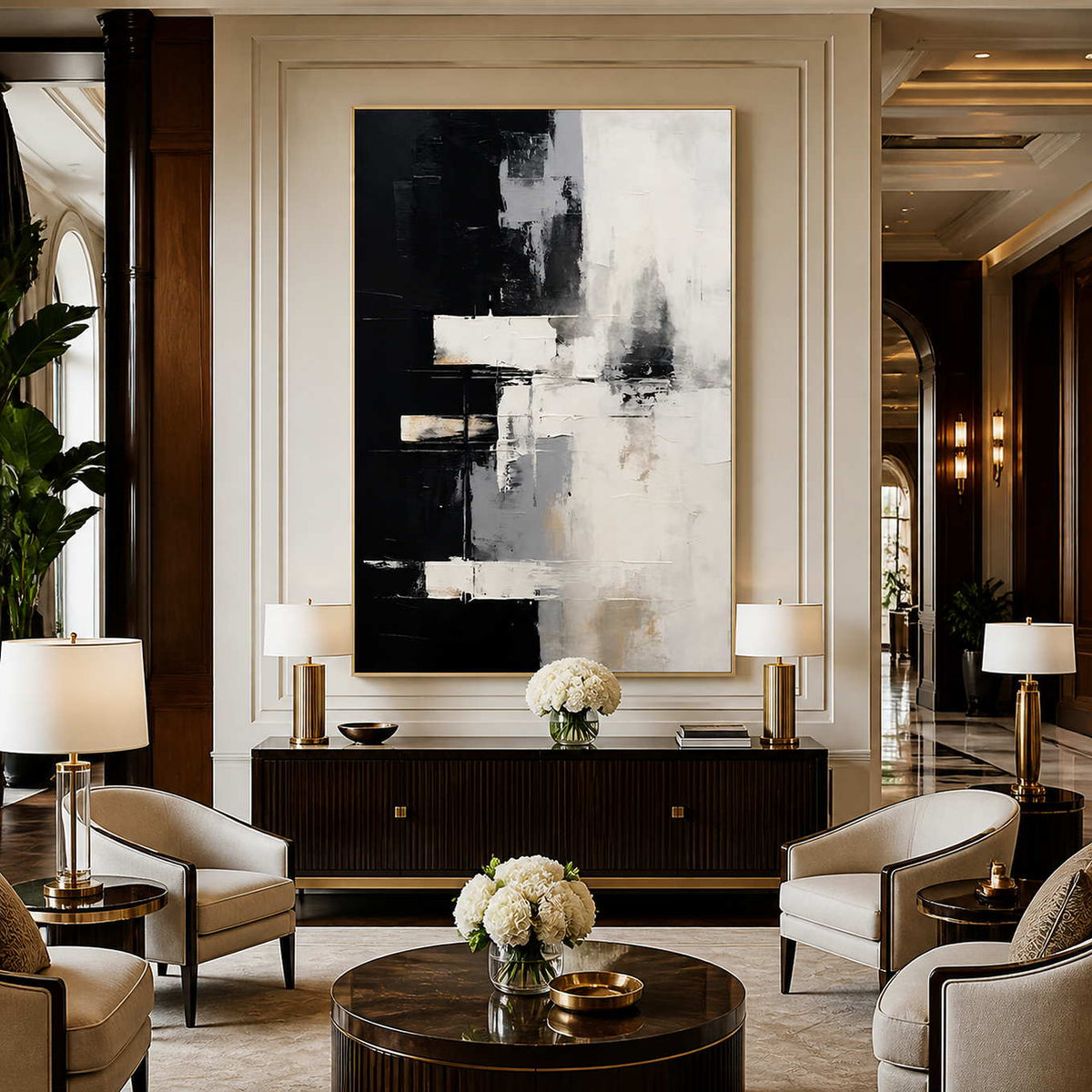 Gold framed black and cream artwork above a fluted cabinet between hotel lounge chairs.