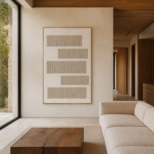 Textured neutral wall art displayed in a warm stone and walnut living room.