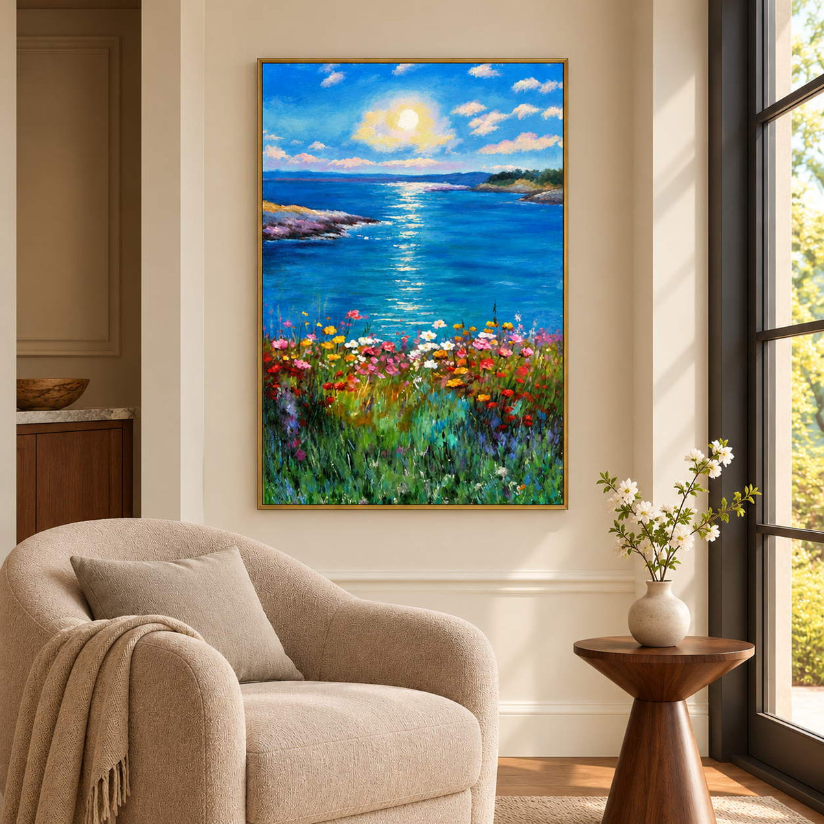 Artwork showing a sunlit blue sea between low shores with colorful flowers in the foreground beside a reading chair, with a gold-colored frame.