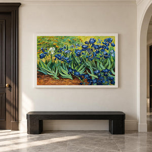 Blue flowers and curling green leaves above warm brown soil in an artwork with no outer frame, displayed in an entryway above a console or bench.
