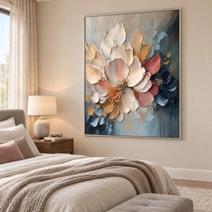 Vertical ivory, blush, and midnight-blue sculpted floral painting, displayed in a bedroom in a silver frame.