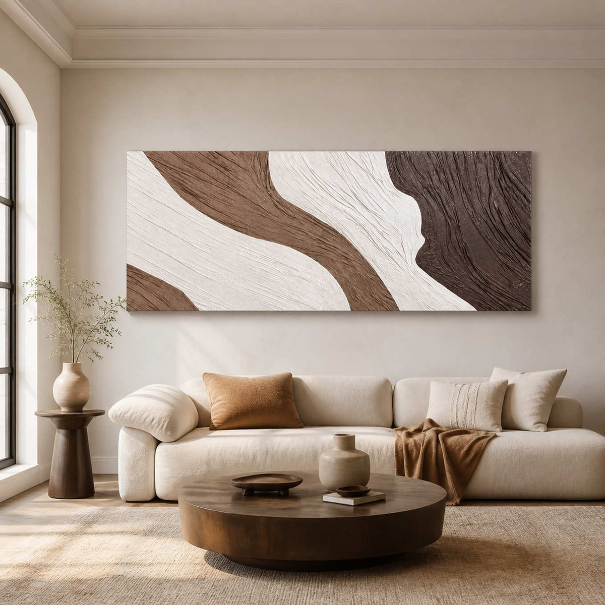 Long textured abstract wall art above a cream sofa and round wooden table.