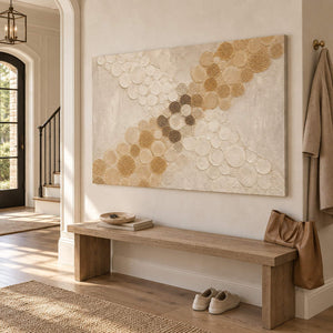 Ivory relief painting with crossing bands of gold and cream circles without an outer frame in an entryway.