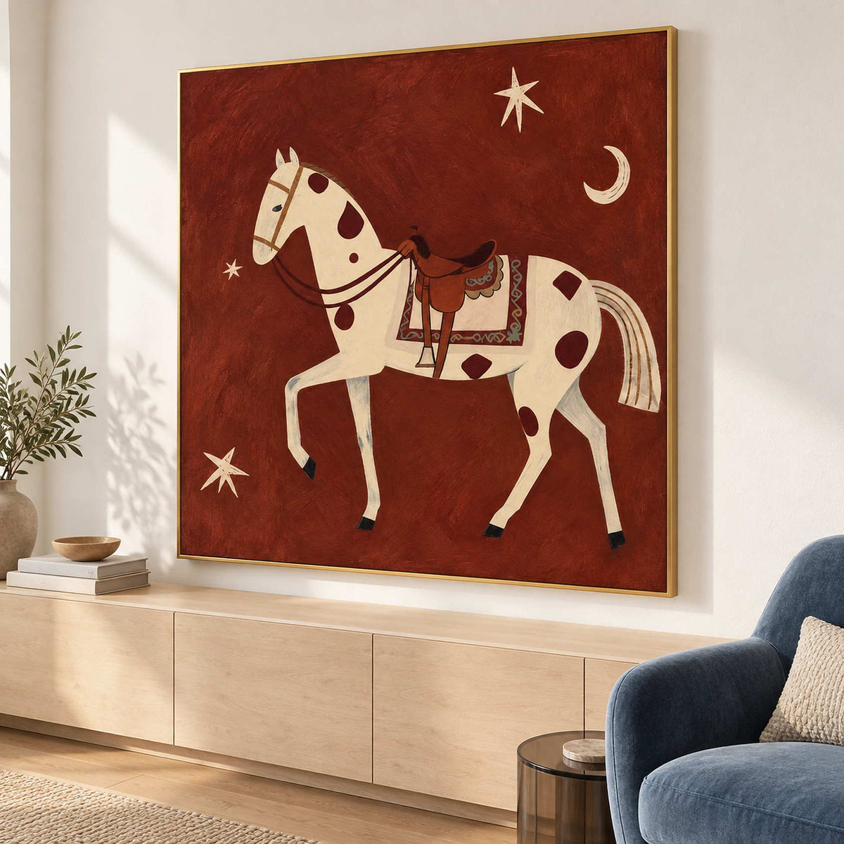Angled equestrian artwork above light cabinetry beside a blue lounge chair.