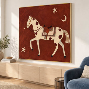Angled equestrian artwork above light cabinetry beside a blue lounge chair.
