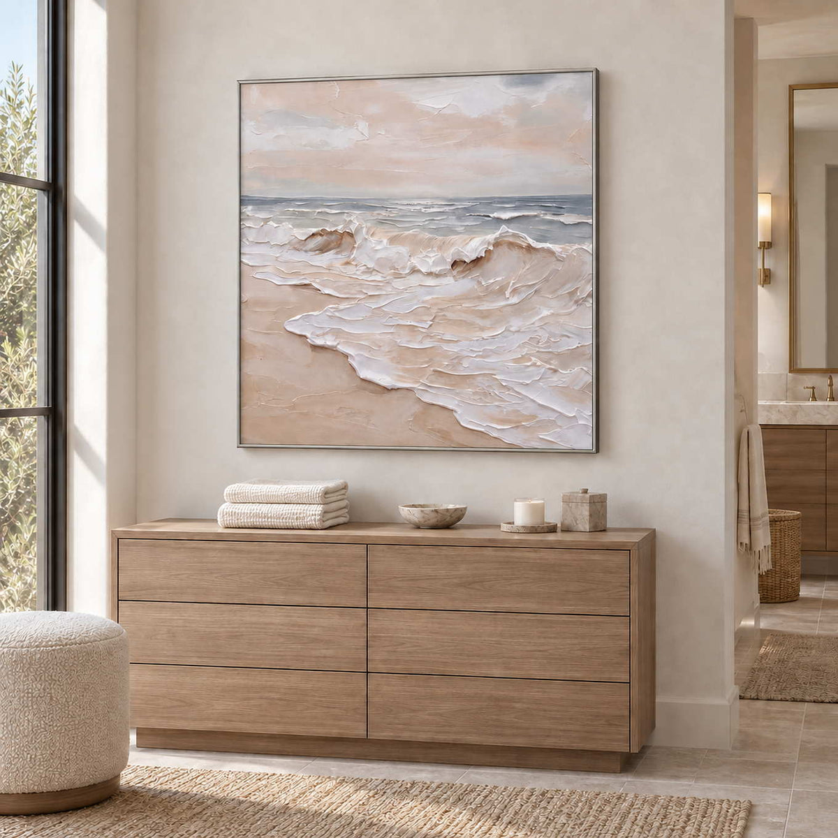 Free as the Sea in a silver frame above a cabinet holding white towels in a bathroom dry area.
