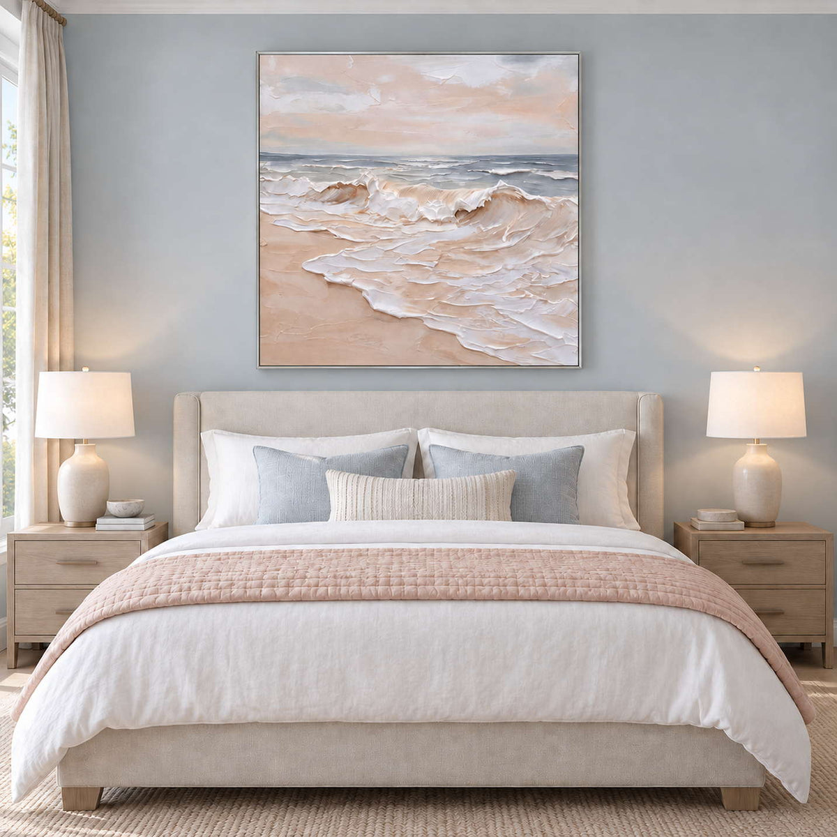 Free as the Sea in a silver frame above a cream bed with a blush throw and blue-gray cushions.