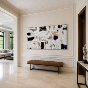 Silver framed flowing abstract artwork above a leather bench in a light entryway.