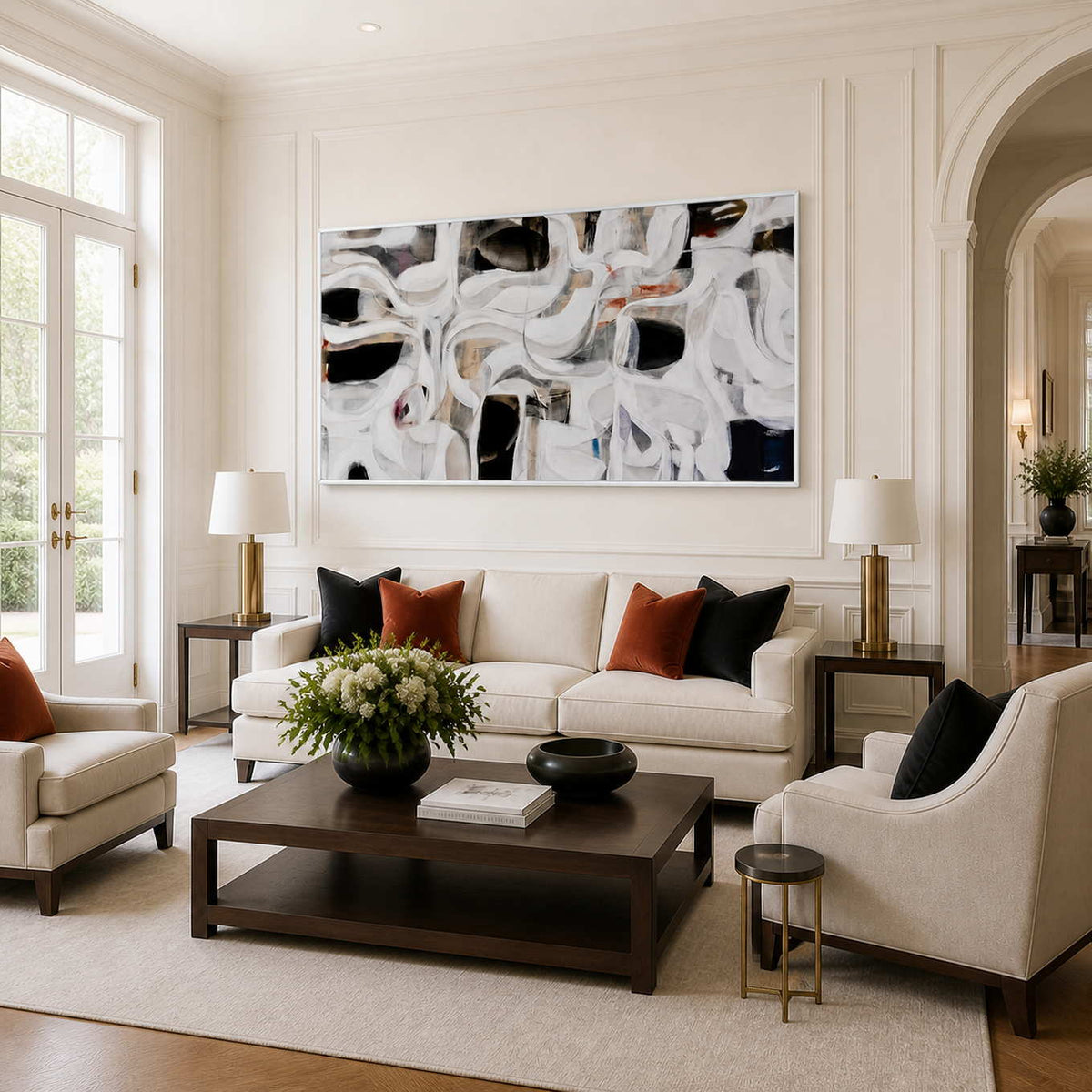 White framed panoramic abstract artwork above a cream sofa with rust accent cushions.
