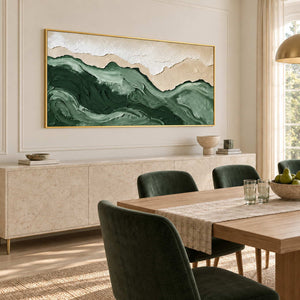 Free to Wander in a gold frame above a pale sideboard beside a wood dining table and deep green chairs.