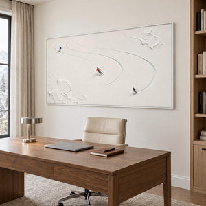 Three skiers tracing curved tracks through fresh white snow in a white frame, displayed in a home office.