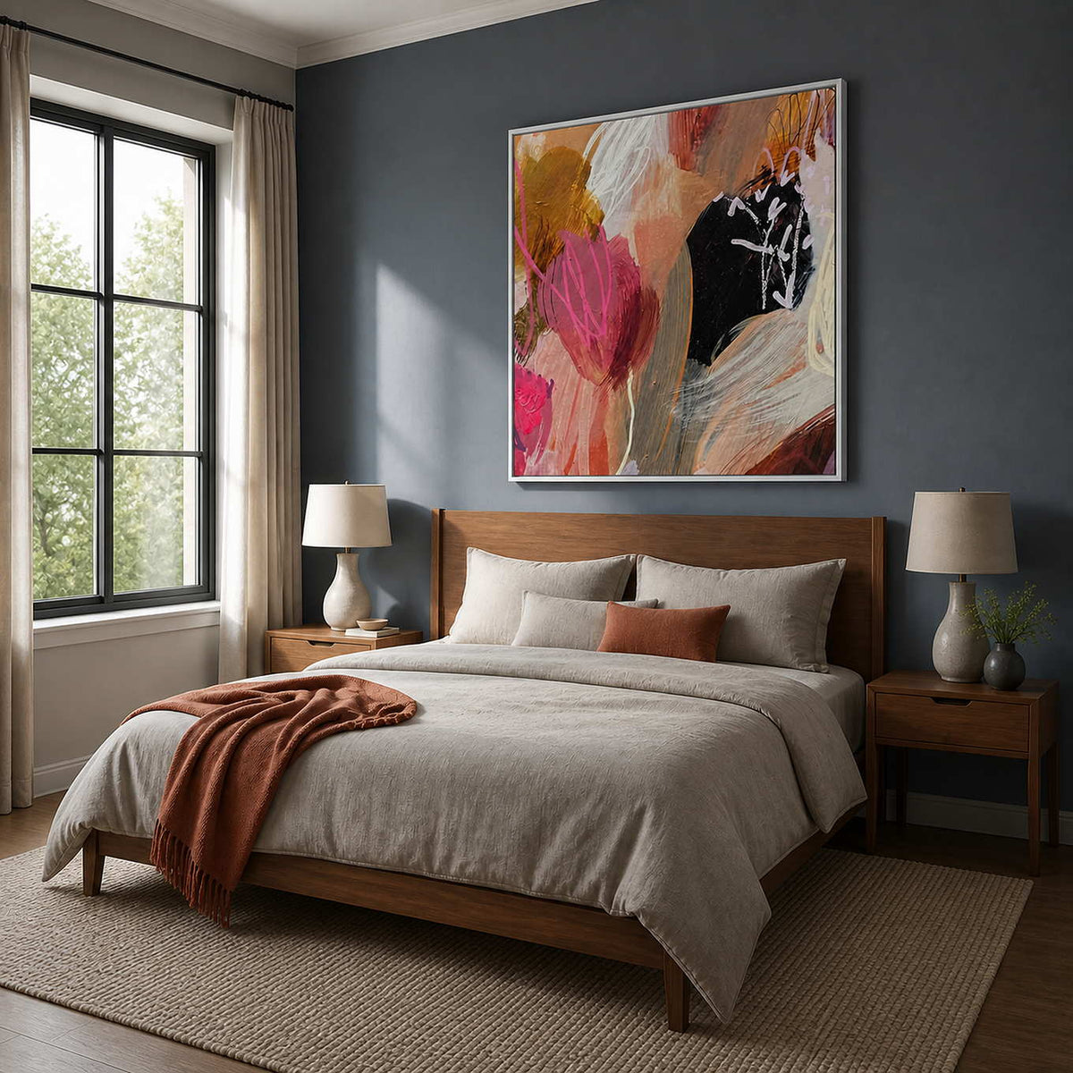 Pink and peach gestural artwork in a white frame above a bedroom headboard.
