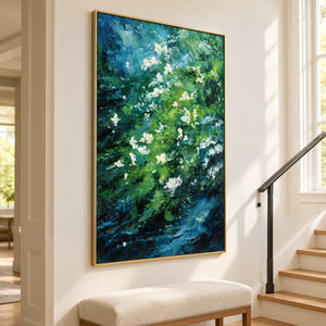 Small white flowers among diagonal layers of green and deep blue strokes in an artwork with a gold-colored frame, displayed beside a staircase.