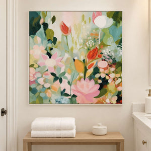 Pink, white and orange flowers among loose green leaves in a white frame, displayed in a bathroom dry area.
