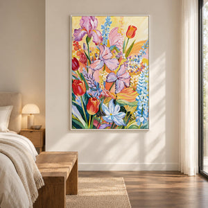 In a bedroom near the bed, an artwork with a white frame shows purple flowers, red cup-shaped blooms and blue-white sprays on yellow.