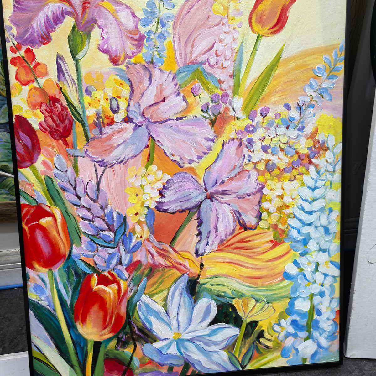 Angled detail of purple petals, red blooms, blue flower spikes and yellow ground.