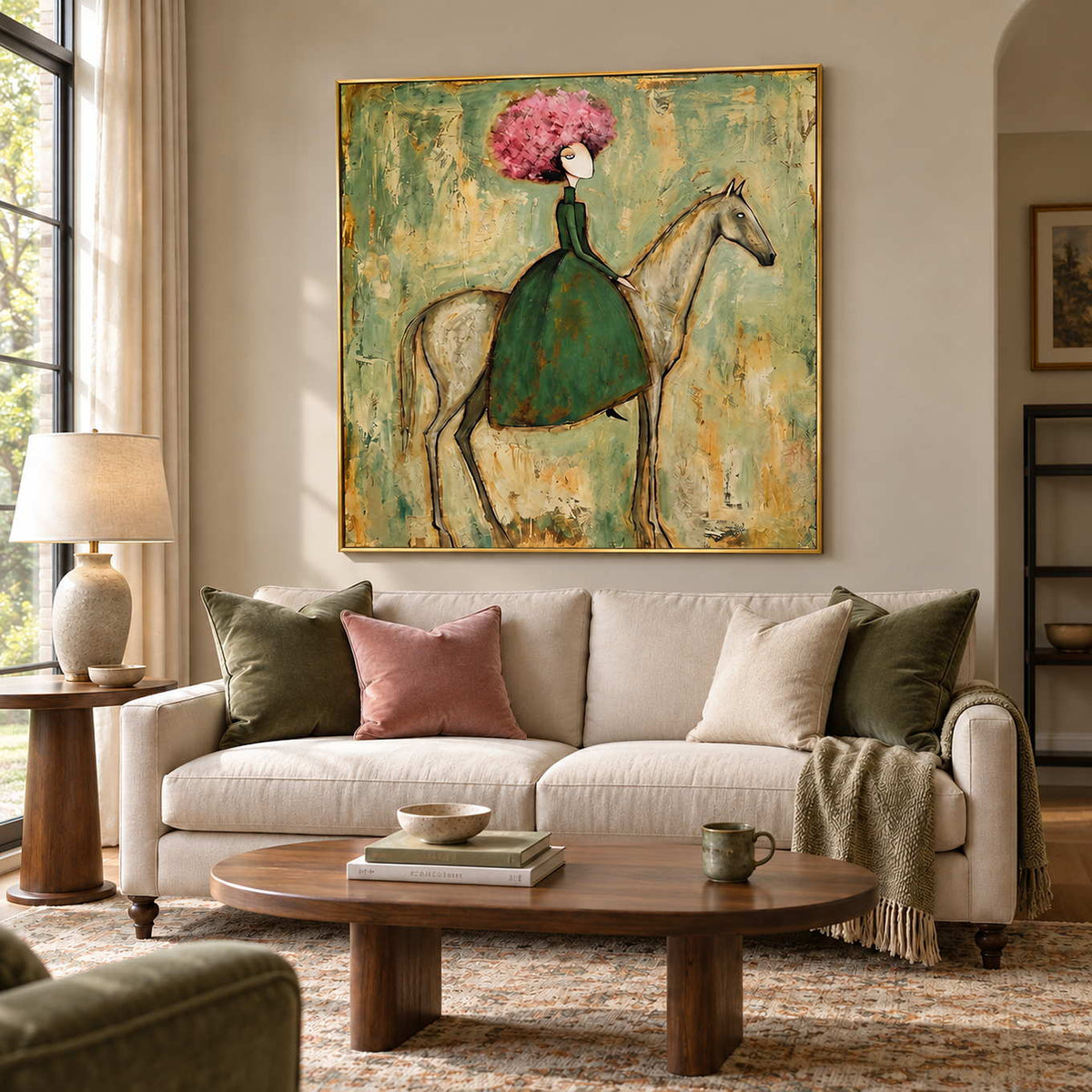 Gentle Company in a gold frame above a cream sofa with green and pink cushions and an oval wood coffee table.