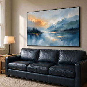 Serene lake landscape above an ink-blue leather family room sofa.
