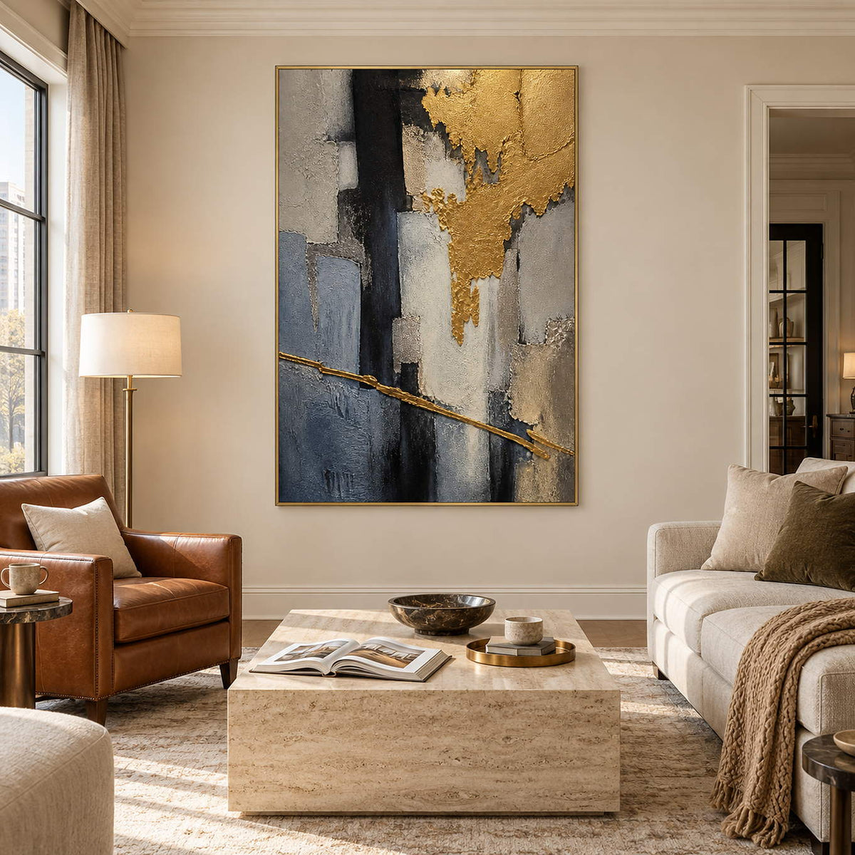 Vertical abstract artwork in gold, charcoal, slate blue, gray, and ivory, displayed in a living room in a gold frame.