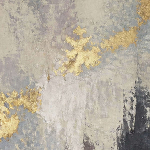 Close-up of broken gold leaf over layered gray painted texture.