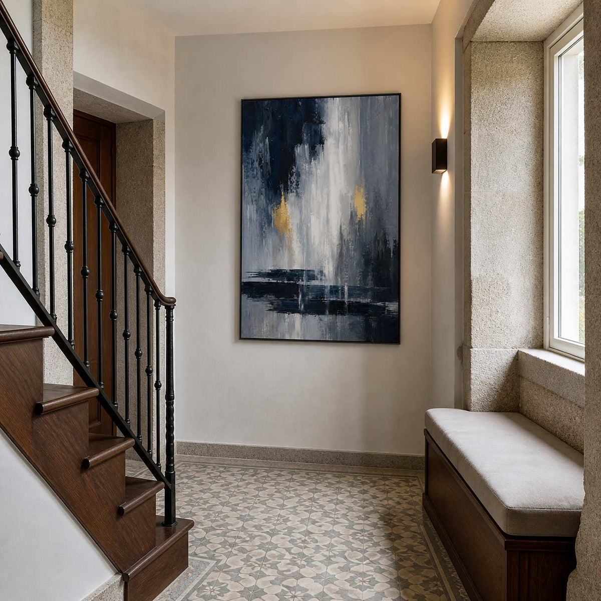 Black and grey abstract artwork styled beside a traditional wood staircase.