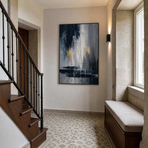 Black and grey abstract artwork styled beside a traditional wood staircase.