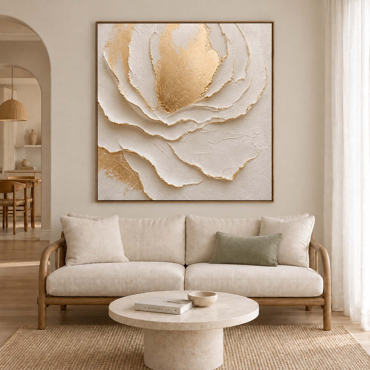 Large layered ivory petals surrounding a gold-toned center in a brown wood frame, displayed above a sofa in a living room.
