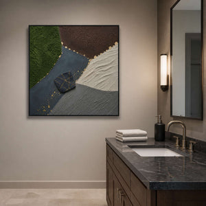 Dark textured abstract wall art in a black frame near a bathroom vanity.