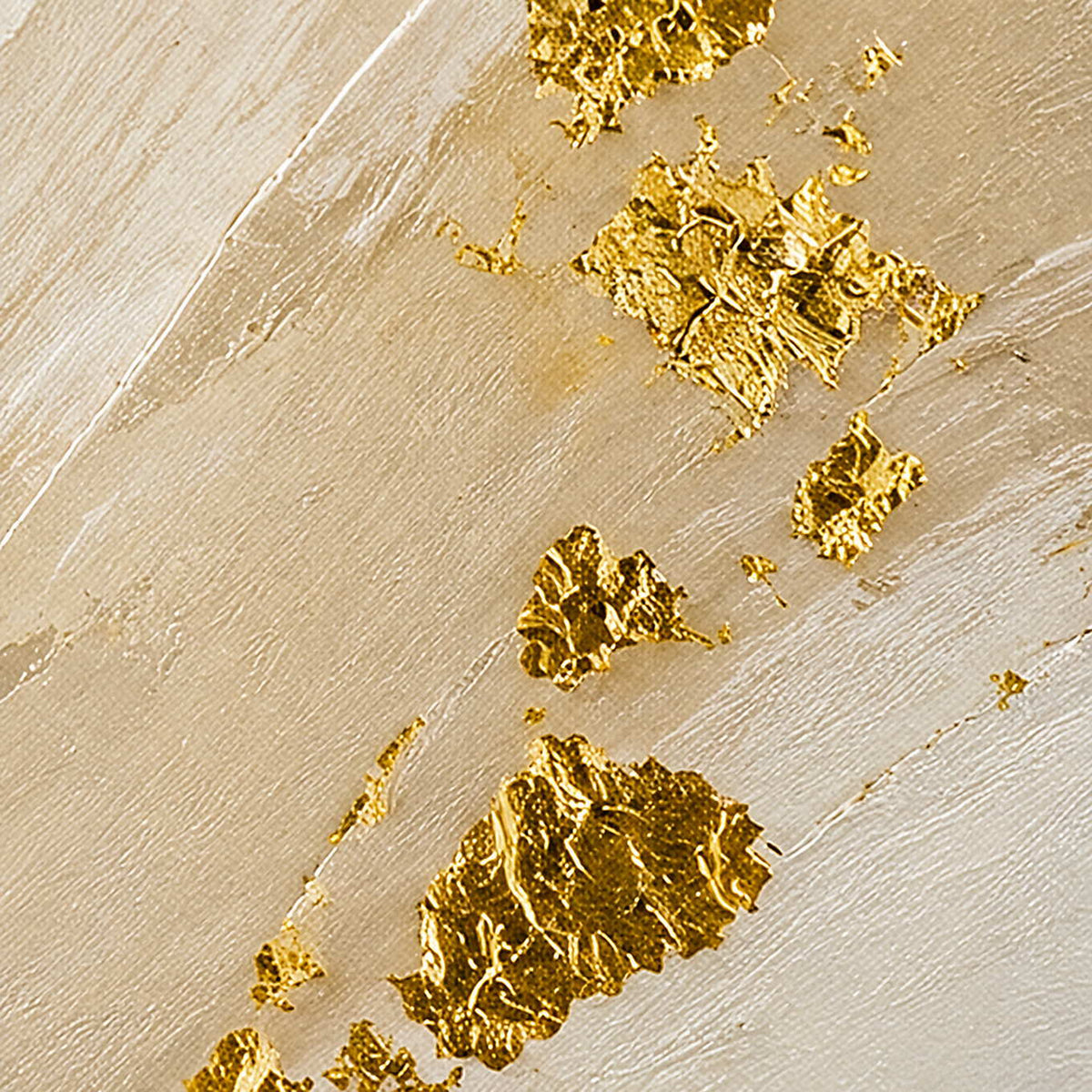 Close-up of raised ivory brushwork and luminous gold leaf texture.
