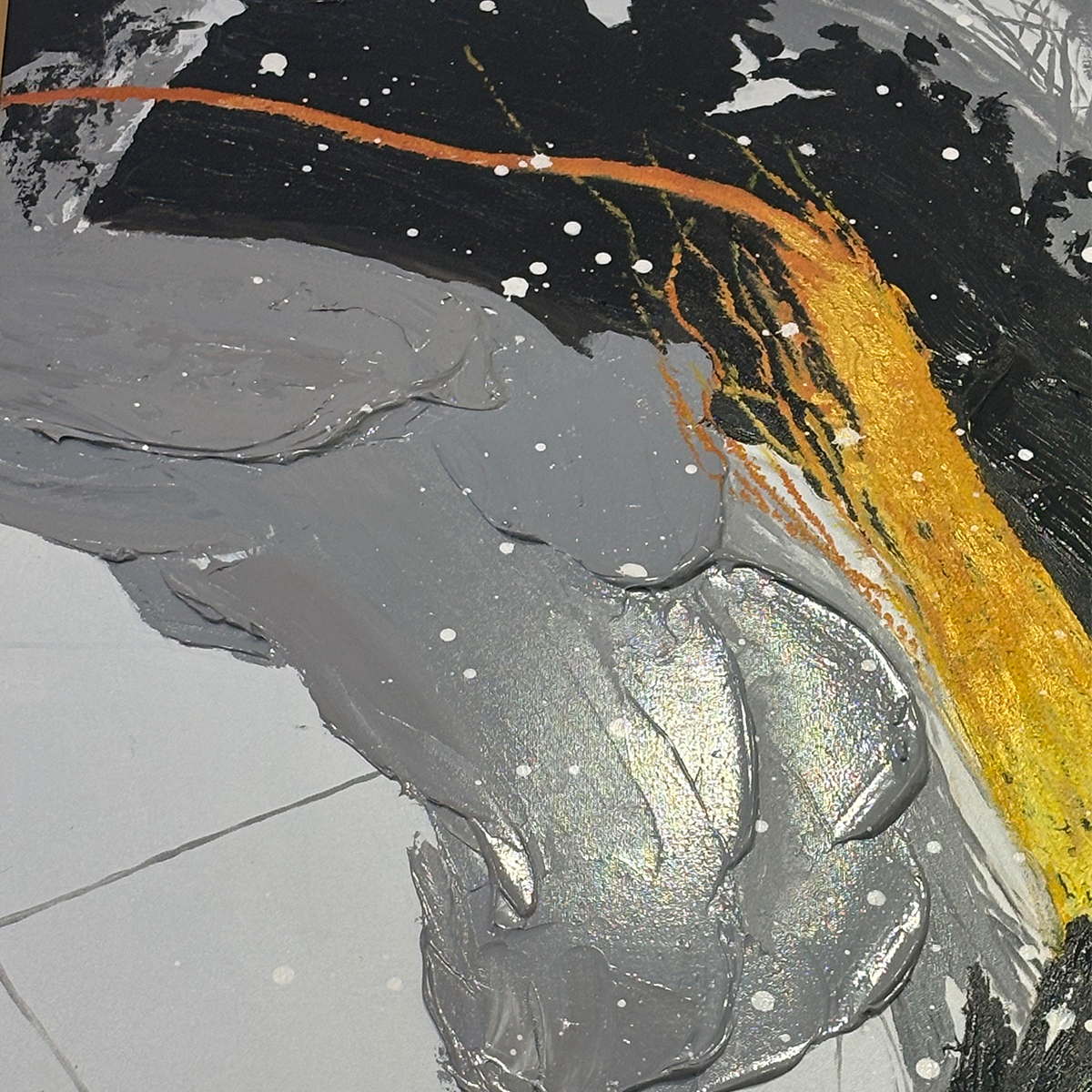 Close-up of a gray raised sweep, black brush band, gold-colored curve and scattered white dots.