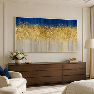 White framed horizontal abstract artwork above a walnut dresser beside an upholstered bedroom chair.