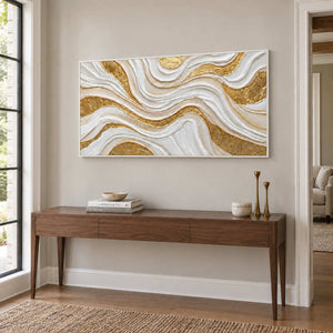 Golden Years in a white frame above a slim wood entryway console with books and tall brass-colored candleholders.