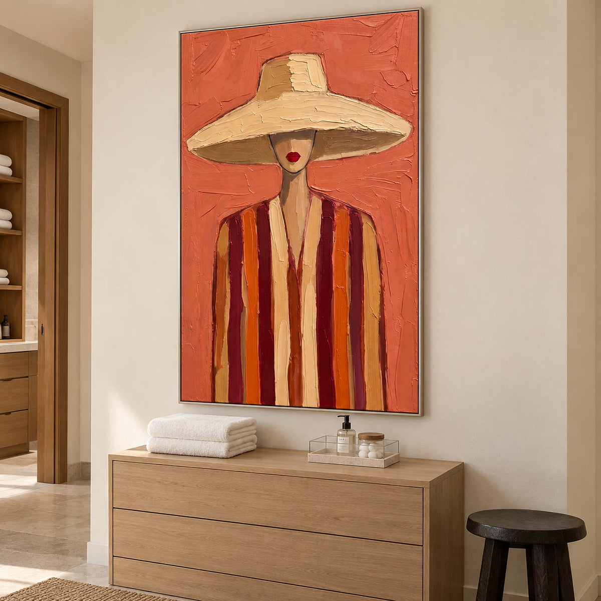 Warm portrait above a wooden dresser holding folded towels and a small tray.