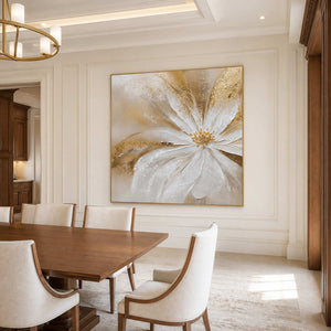 Gold-framed Grace in Bloom on a dining room wall beside a long wood table and cream chairs.