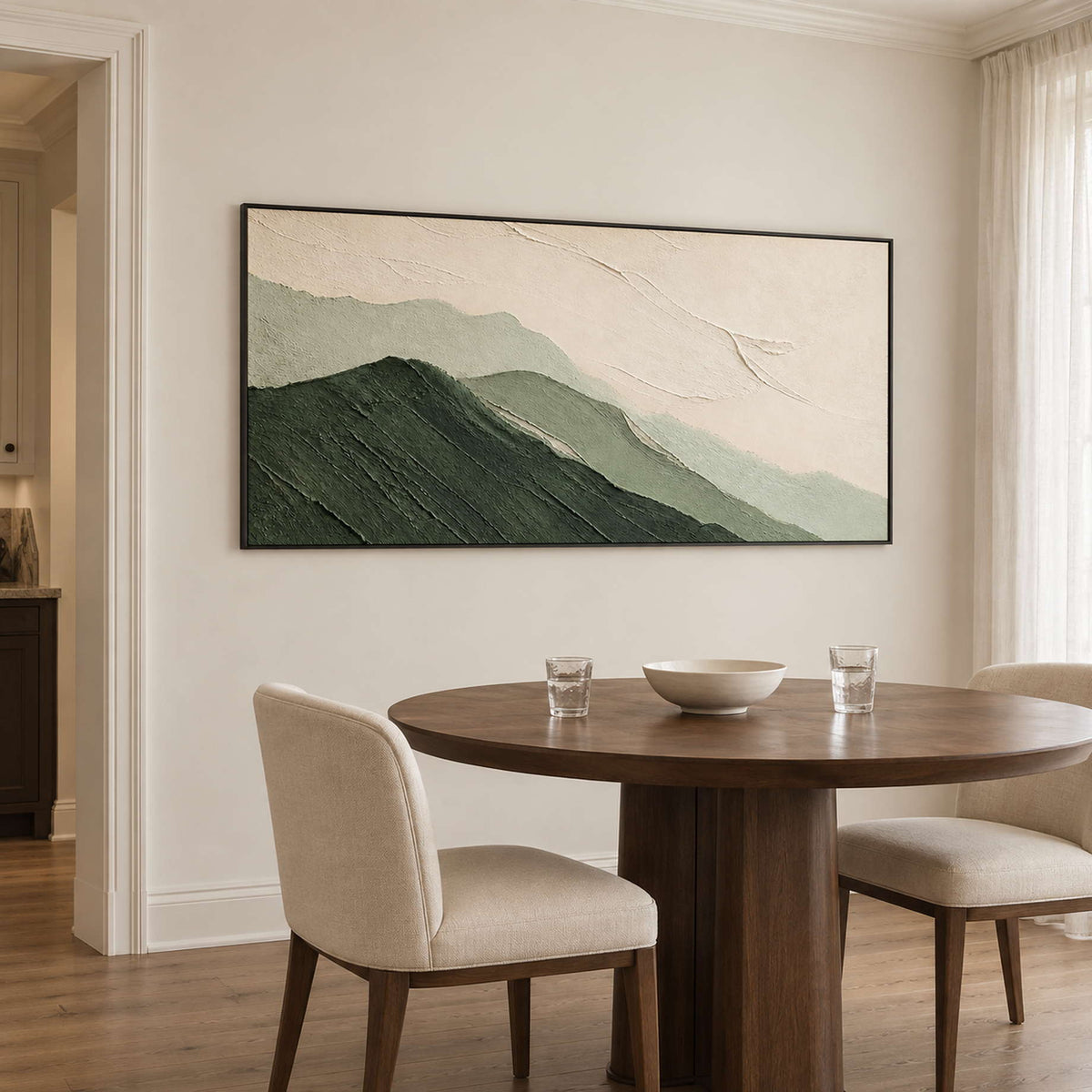 Layered dark and pale green mountains beneath an ivory sky in a black frame, displayed above a dining table.