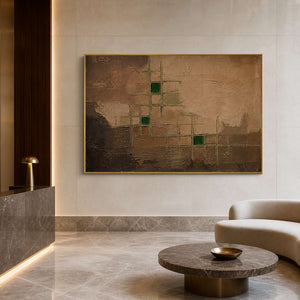 Earth tone abstract artwork in a gold frame inside a refined lobby.