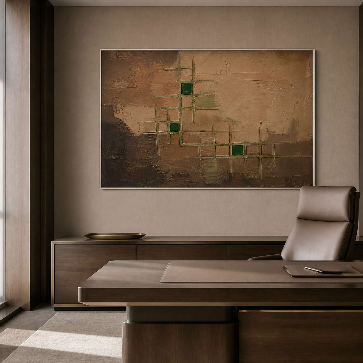Structured green and brown artwork in a silver frame inside an office.