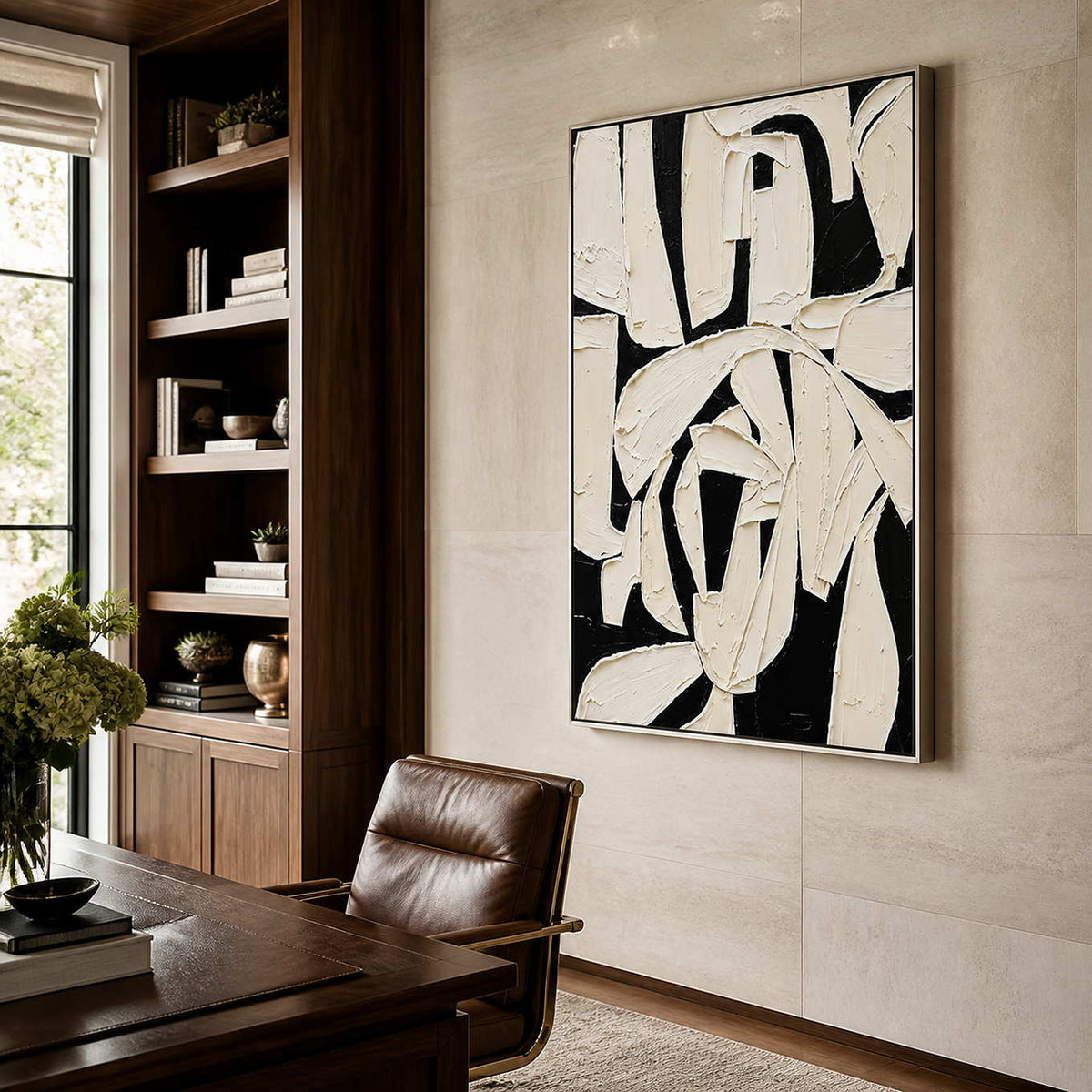 Silver framed abstract artwork with broad ivory strokes beside a home office bookshelf.