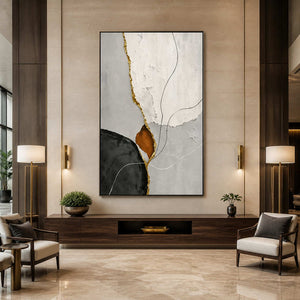Black framed abstract artwork with delicate curves between lamps in a hotel lobby.